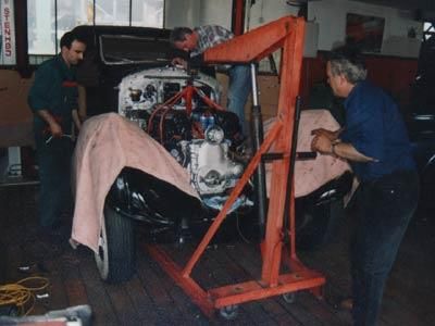 Ein Mann arbeitet in einer Garage an einem Automotor