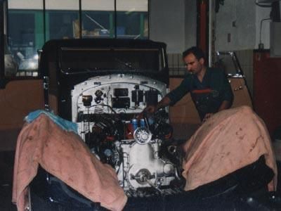 Ein Mann arbeitet in einer Garage an einem Automotor