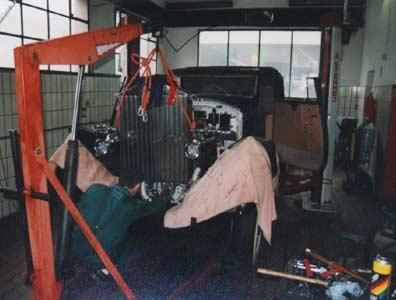 Ein Mann arbeitet in einer Garage an einem Automotor