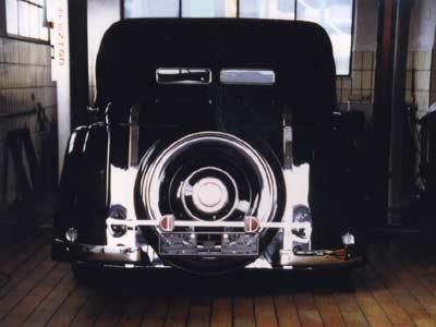 Ein schwarzes Auto steht in einer Garage mit einem Reifen auf der Rückseite