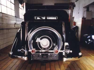 Ein schwarzes Auto steht auf einem Holzboden in einer Garage