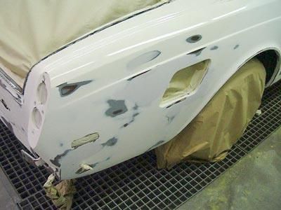 Ein weißes Auto wird in einer Garage lackiert.