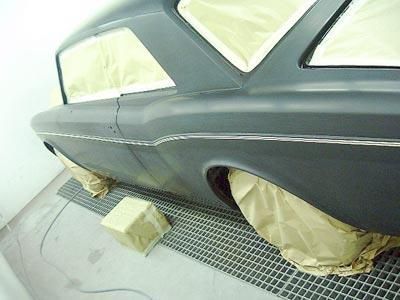 Ein schwarzes Auto wird in einer Lackierkabine lackiert