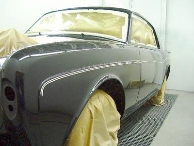 In einer Lackierkabine wird ein Auto lackiert.