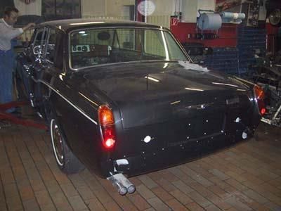 Ein Mann arbeitet in einer Garage an einem schwarzen Auto