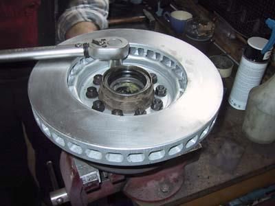 Eine Person bearbeitet mit einem Schraubenschlüssel eine Bremsscheibe.