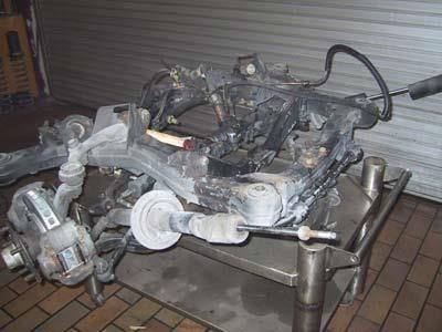 Ein Automotor steht auf einem Metallregal.