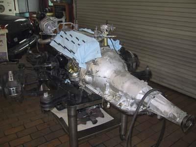 Ein Automotor steht auf einem Tisch in einer Garage.