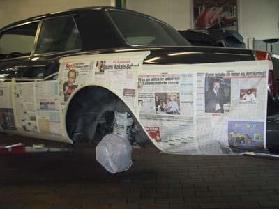 Ein Auto ist in einer Garage mit Zeitungen bedeckt