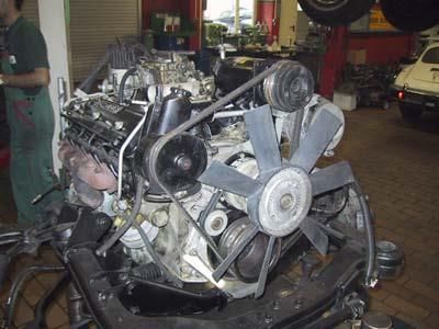 Ein Mann arbeitet in einer Garage an einem Automotor