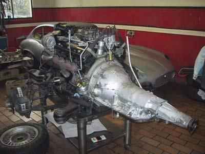 Ein Automotor und ein Getriebe stehen auf einem Tisch in einer Garage.