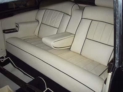 Der Rücksitz eines Autos mit weißen Ledersitzen