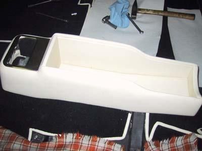 Ein weißer Behälter steht auf einem Tisch neben einem Hammer