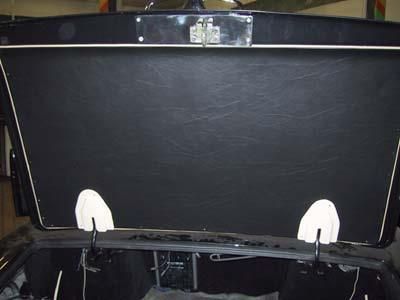 Der Kofferraum eines schwarzen Autos mit geöffneter Motorhaube.