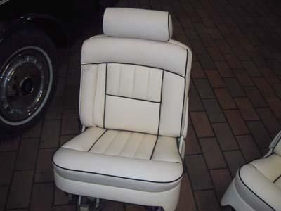 Vor einem schwarzen Auto steht ein weißer Autositz.