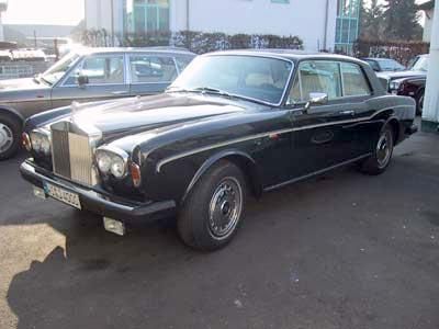 Auf einem Parkplatz steht ein schwarzes Rolls-Royce-Coupé.