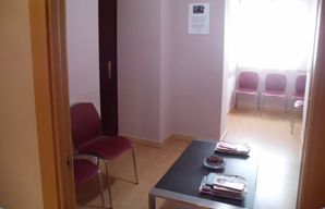 Una sala de espera con una mesa y sillas.