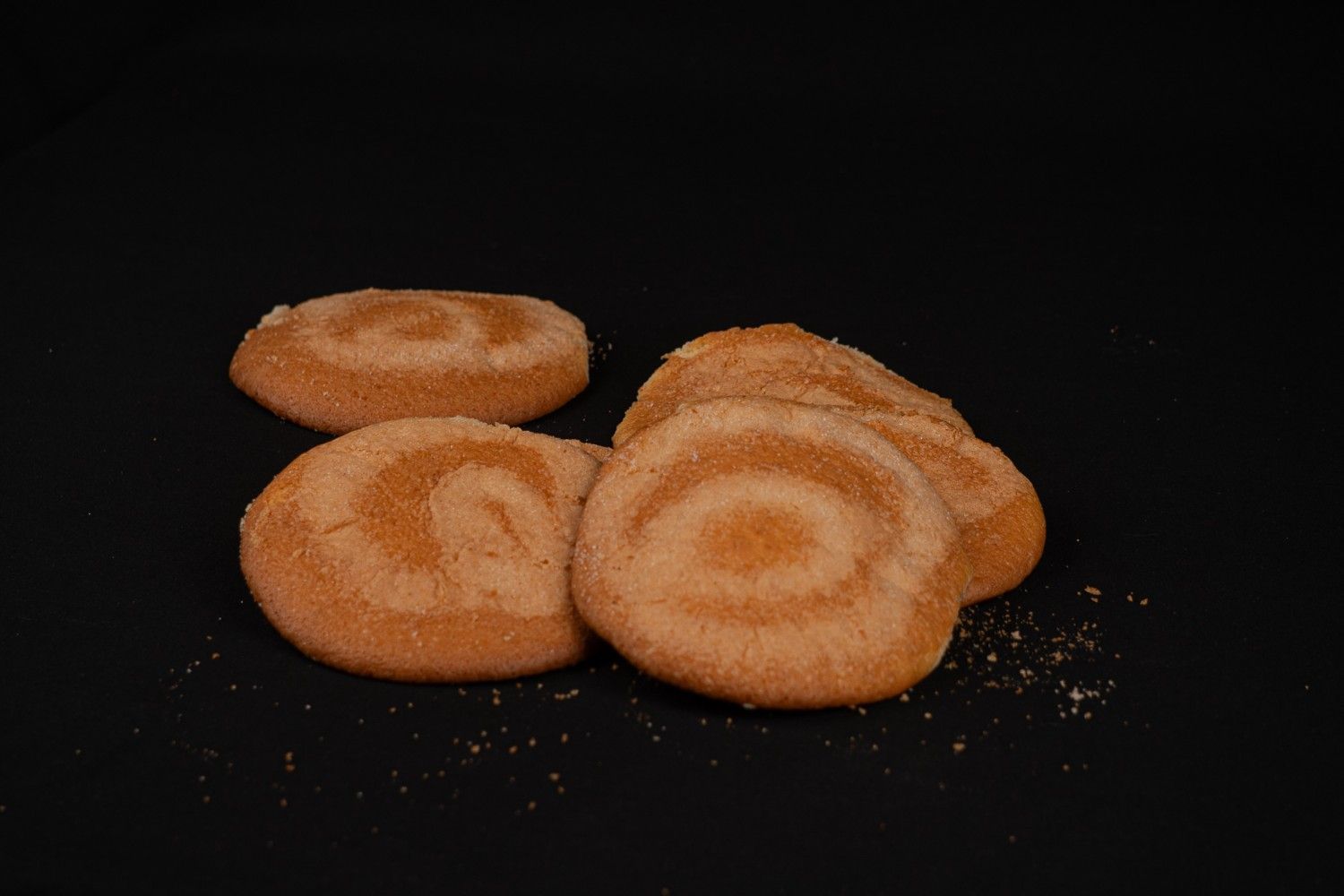 Varias hogazas redondas y rústicas de pan de masa madre con la parte superior marcada, dispuestas en una cesta de mimbre.
