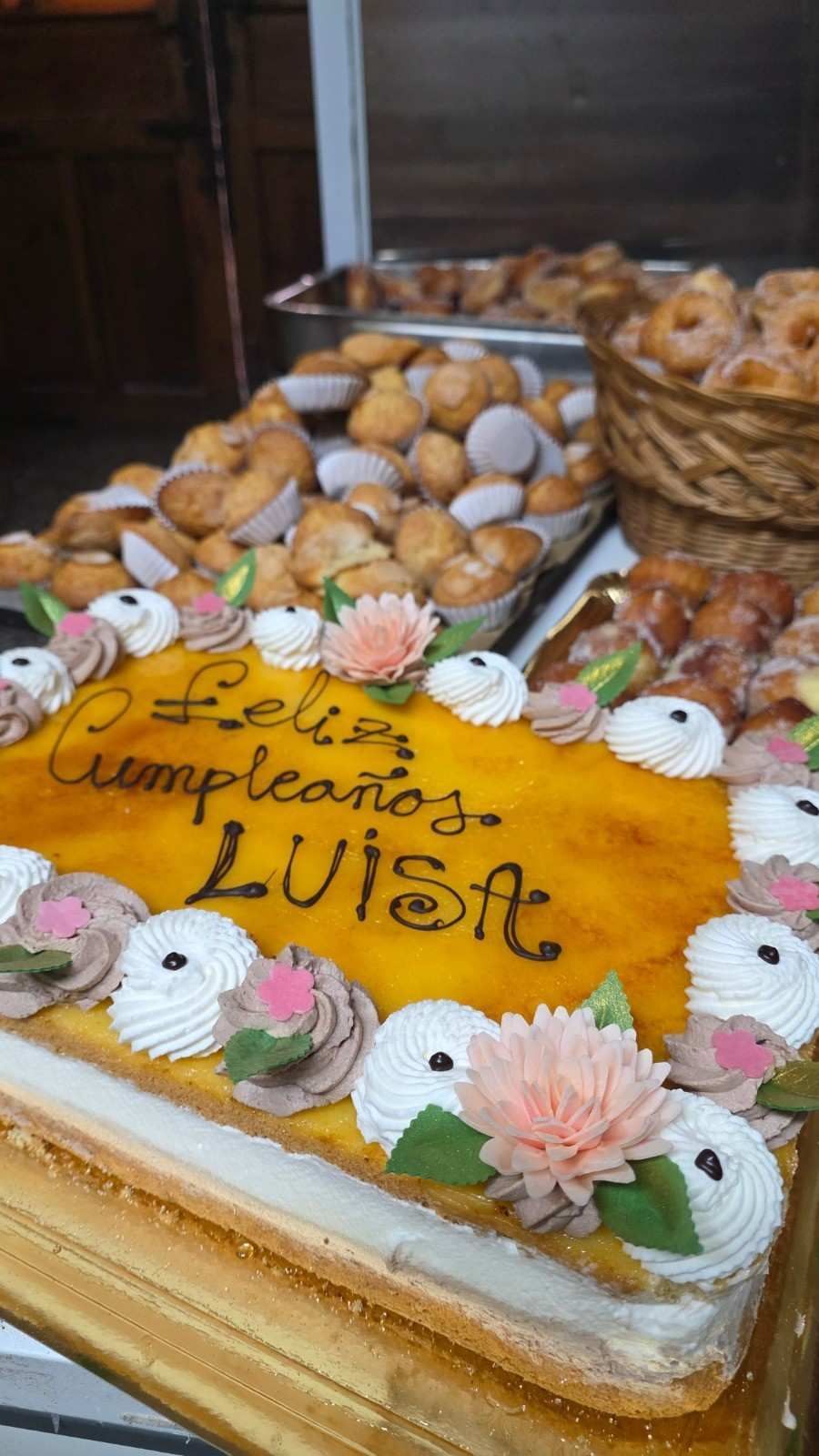 En una cesta de mimbre poco profunda reposa una hogaza grande y redonda de pan artesanal, crujiente.