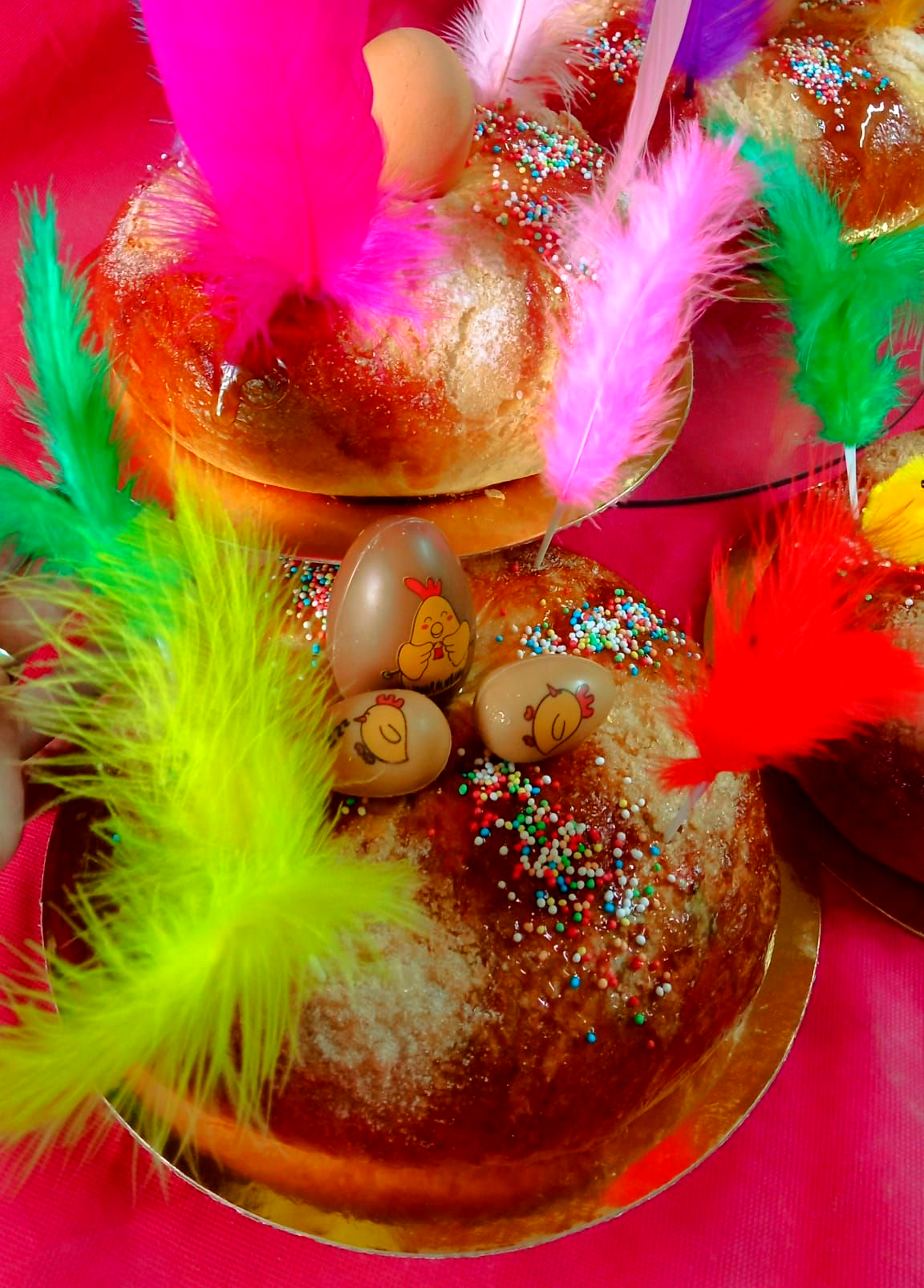 Roscas con huevo decoradas con plumas brillantes y perlas de azúcar