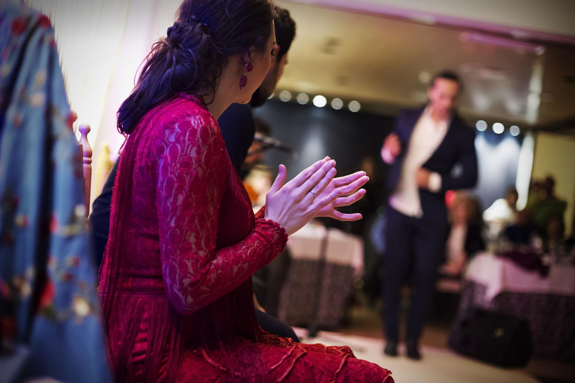 Una mujer con un vestido rojo aplaude en una recepción de boda.