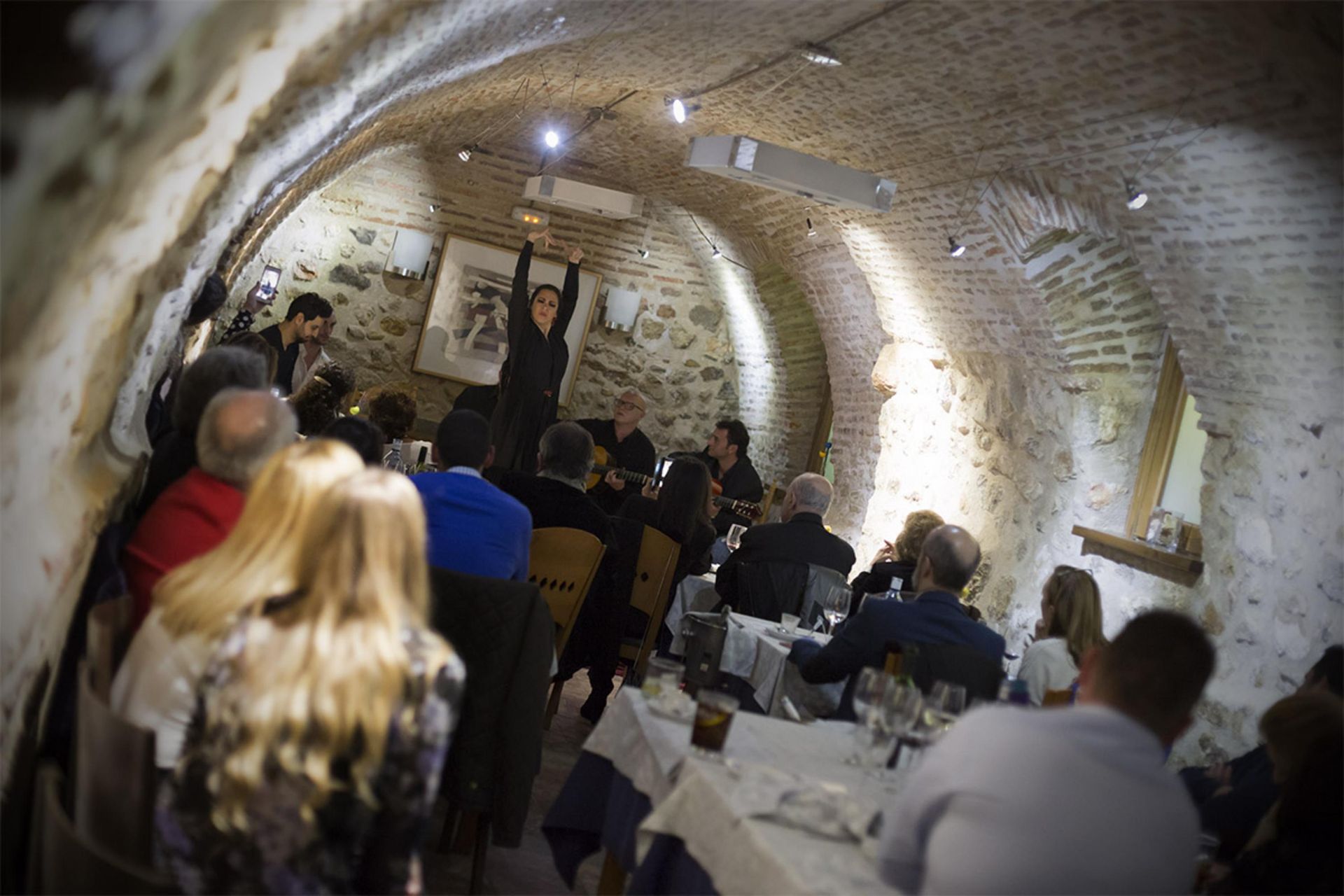 Un grupo de personas están sentadas en mesas en un restaurante.
