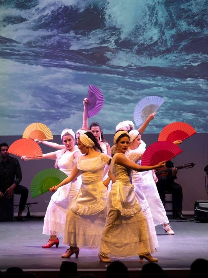 Un grupo de mujeres baila en un escenario con fans.
