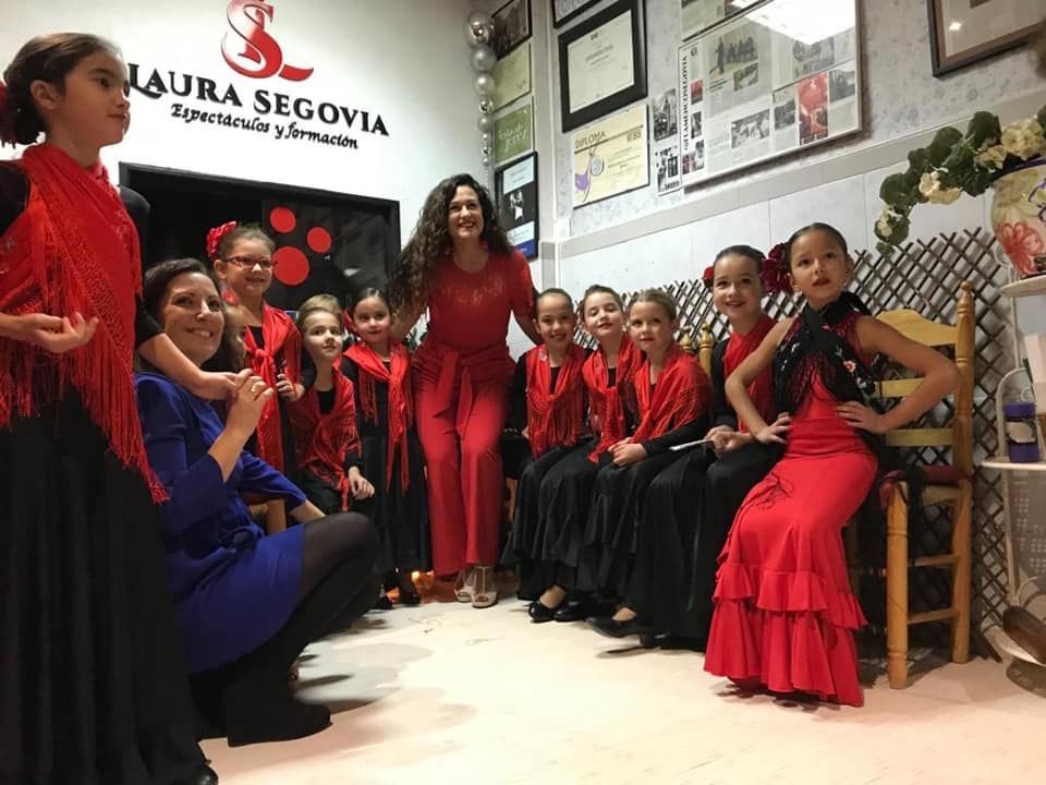 Un grupo de mujeres baila en un escenario con fans.