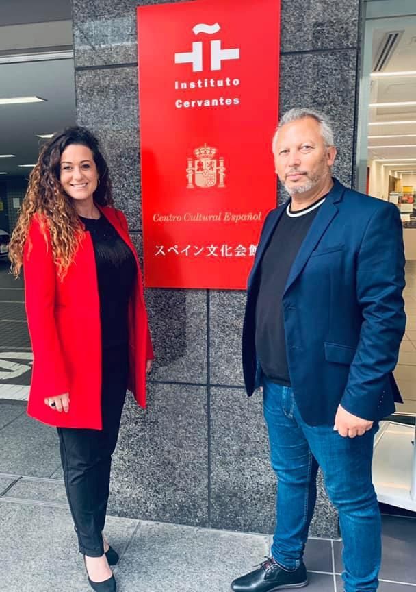 Un hombre y una mujer están parados frente a un cartel que dice Instituto Cervantes.
