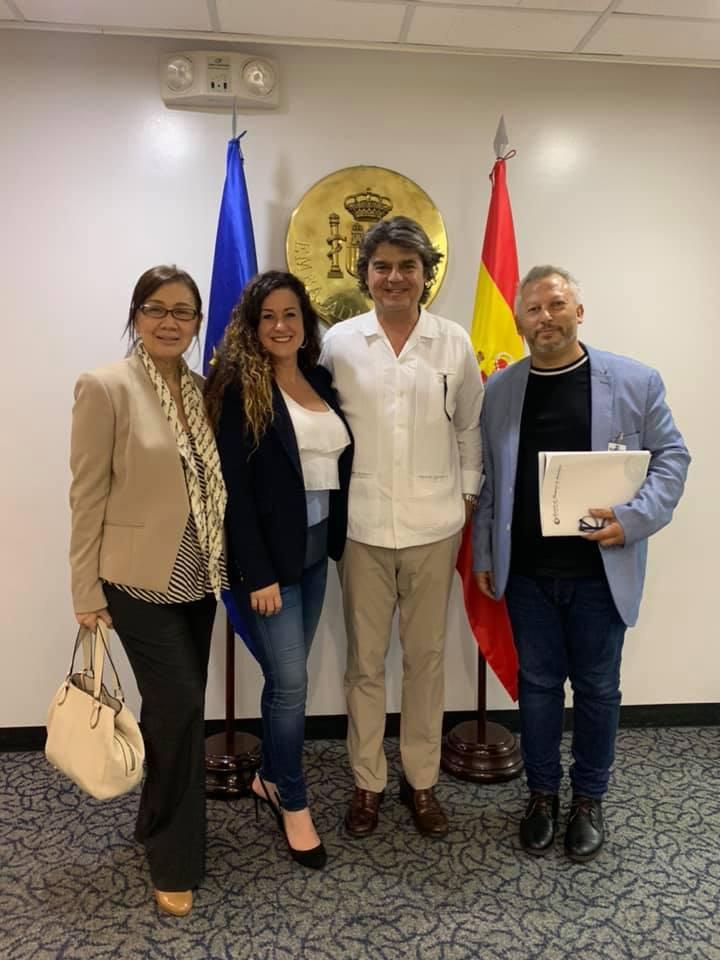 Un grupo de personas posando para una foto frente a banderas.
