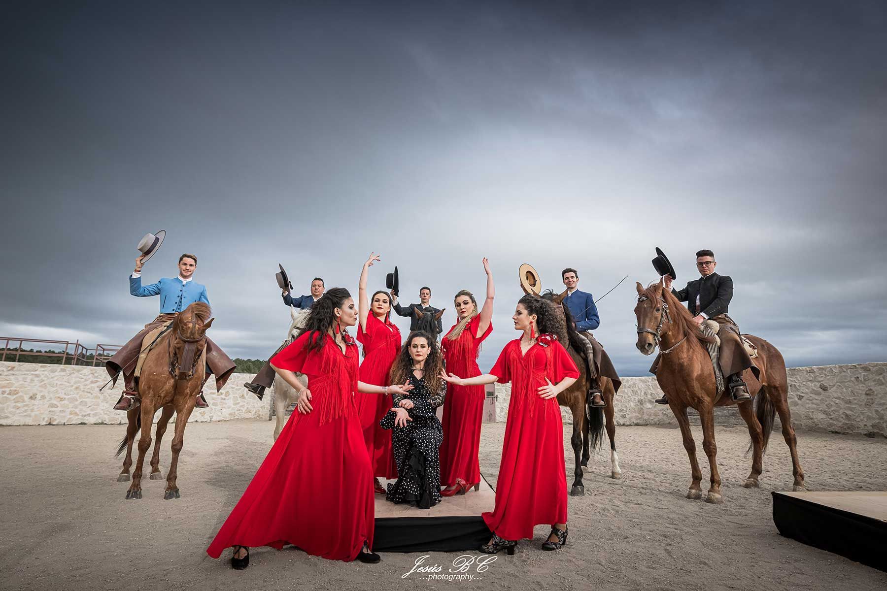 Un grupo de personas vestidas de rojo están de pie junto a los caballos.