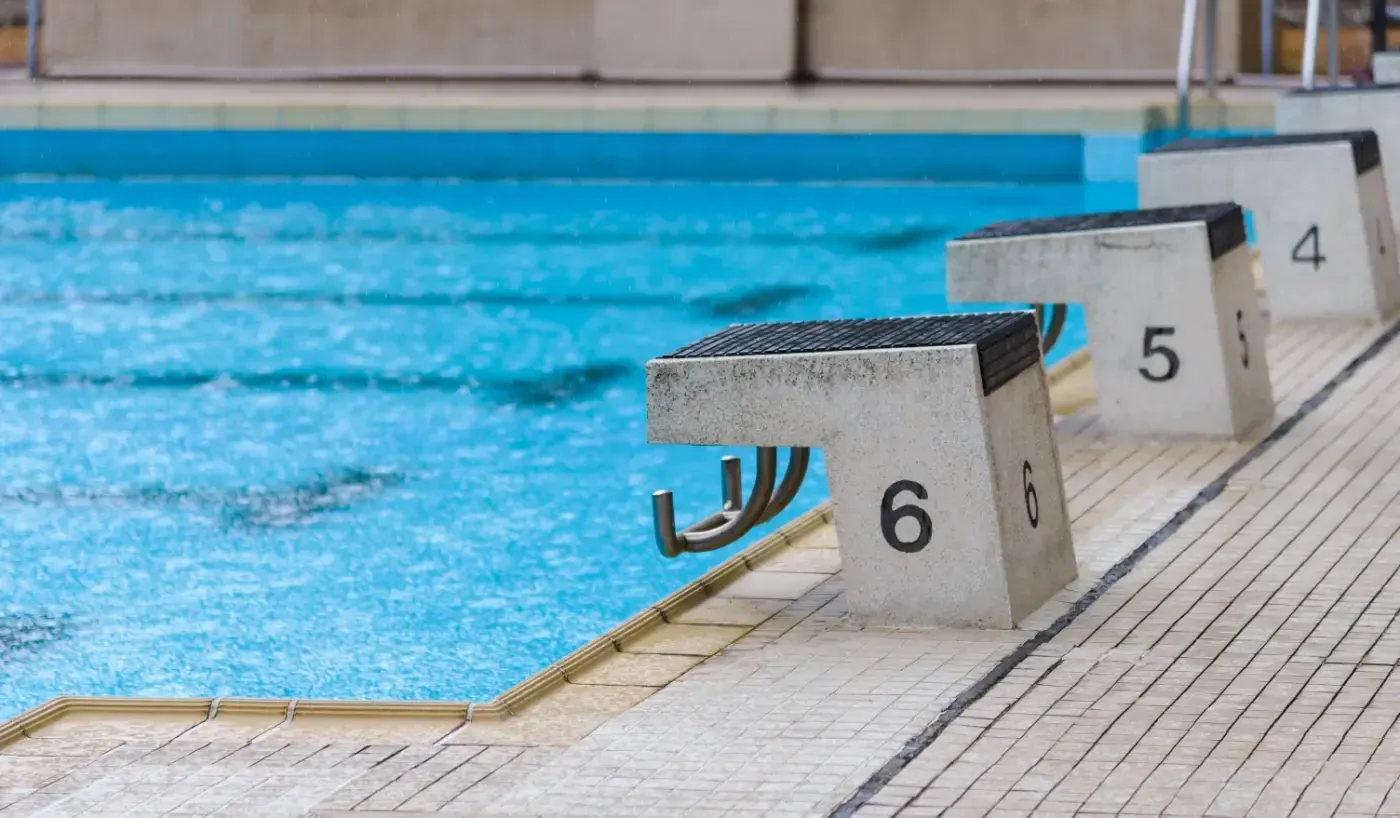 Am Rand eines hellblauen Schwimmbeckens stehen die Startblöcke 4, 5 und 6.