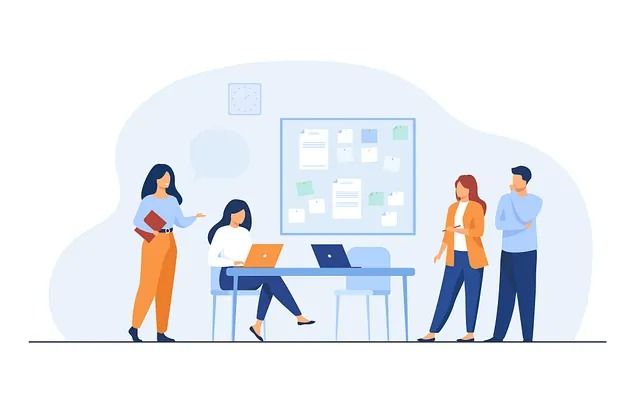 Un grupo de personas están de pie alrededor de una mesa con computadoras portátiles.