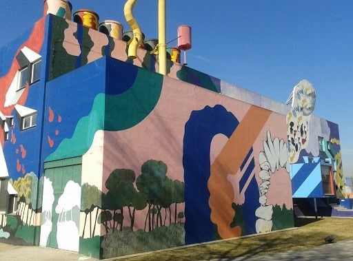 Un edificio con un mural colorido en el costado.