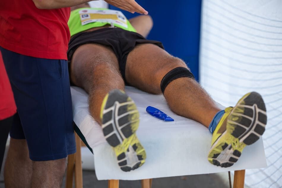 Un hombre está recibiendo un masaje en su pierna sobre una mesa.