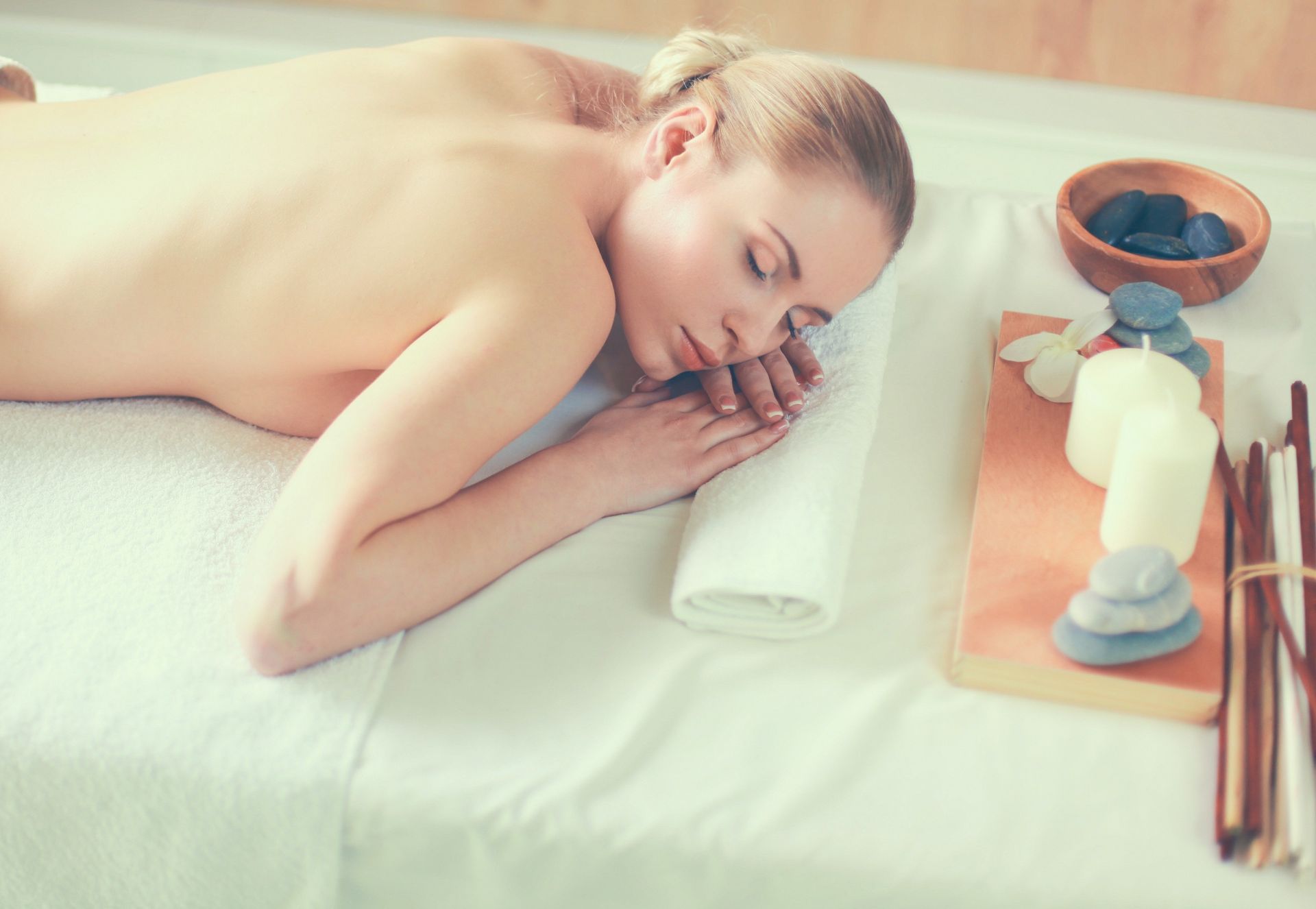 Una mujer está acostada en una mesa de masajes en un spa.