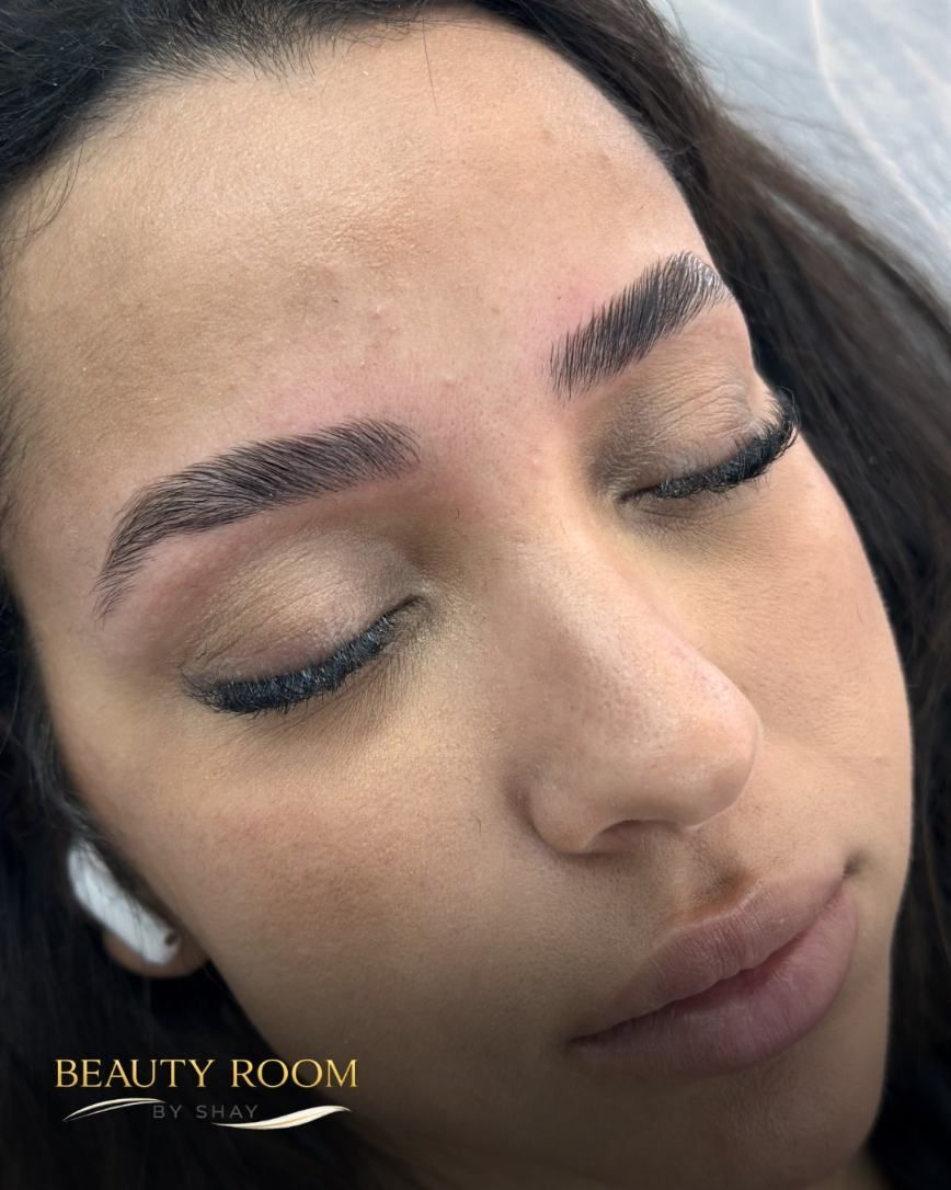Primer plano de una mujer con los ojos cerrados, cejas bien definidas y maquillaje neutro, que lleva un auricular blanco.