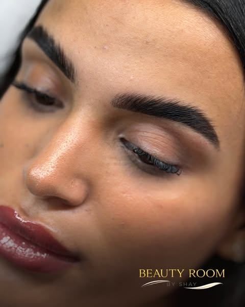 Primer plano del rostro de una mujer con labios brillantes y maquillaje de ojos suave y neutro.