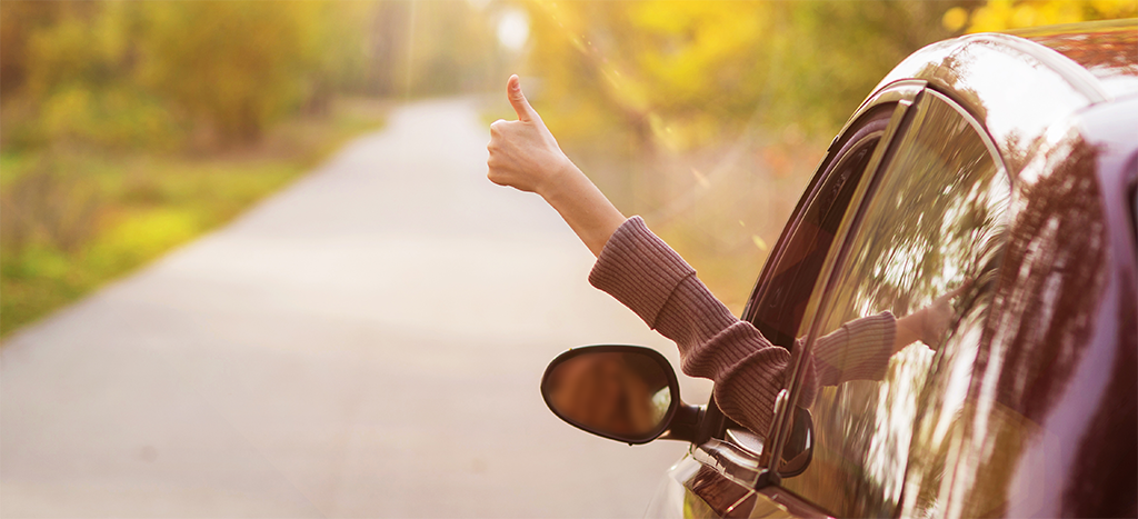 Une personne en voiture avec le pouce en l'air