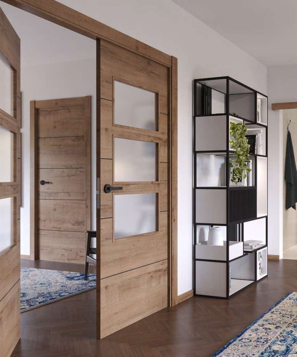 Vista interior que muestra puertas de madera con paneles de vidrio esmerilado y una moderna estantería de metal negro sobre un suelo de madera.