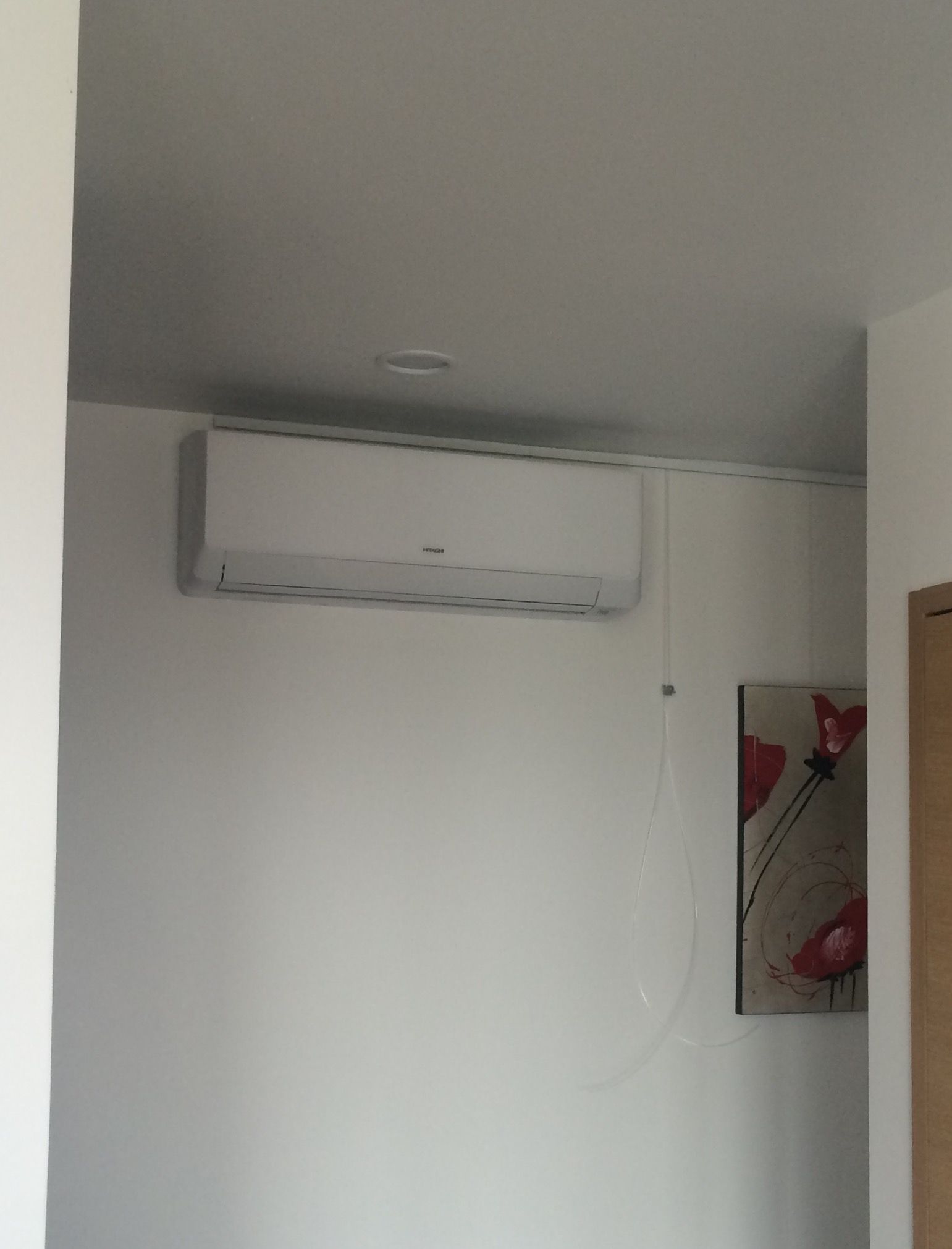 Un climatiseur installé en haut d'un mur dans une pièce intérieure