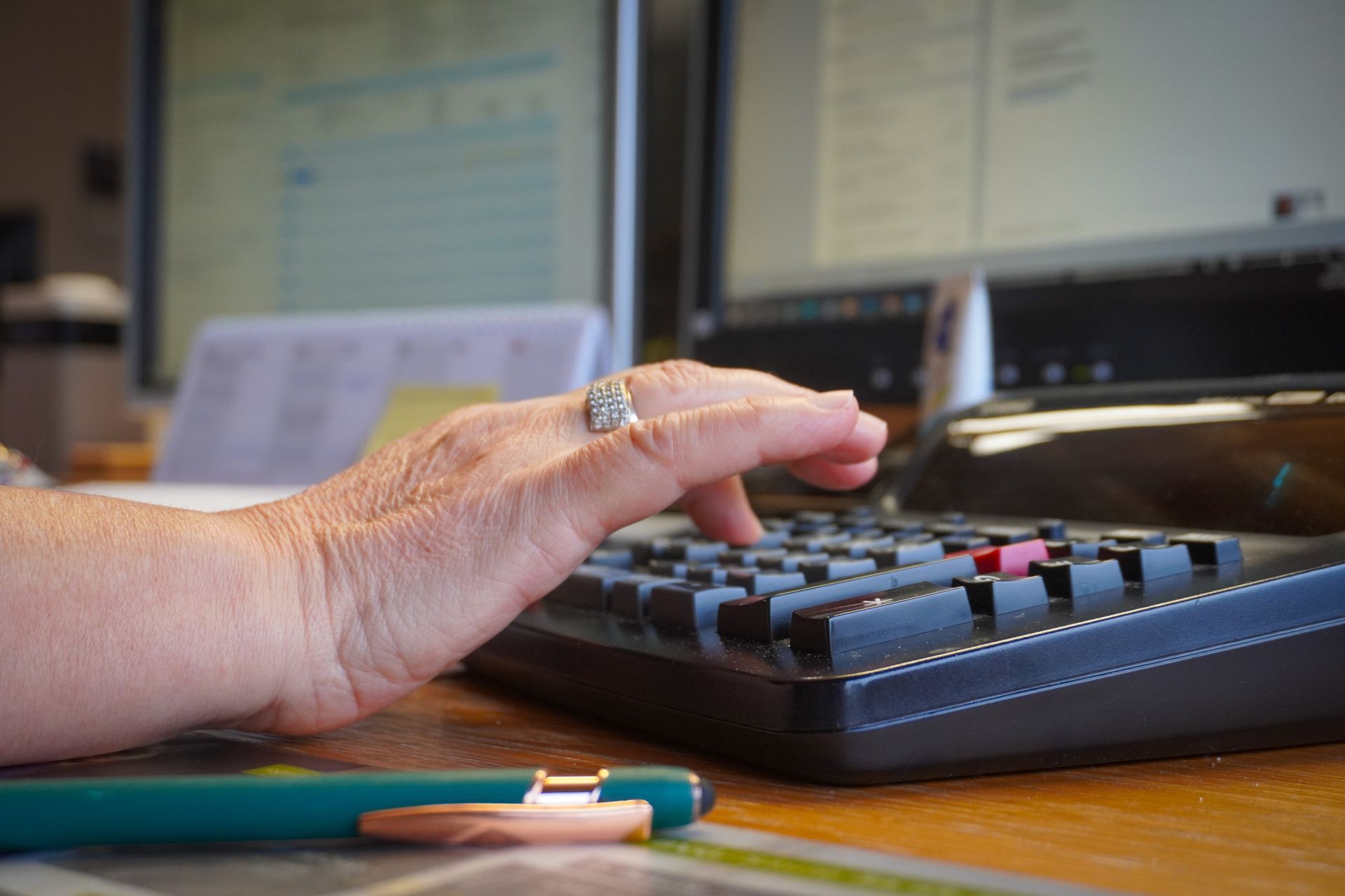 Vier ausgeschnittene Figuren mit Fragezeichen, Zahnrädern, Glühbirne und Ausrufezeichen auf einer Holzoberfläche, die ein Brainstorming symbolisieren.