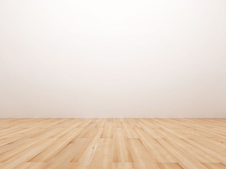 Du parquet clair et un mur blanc.