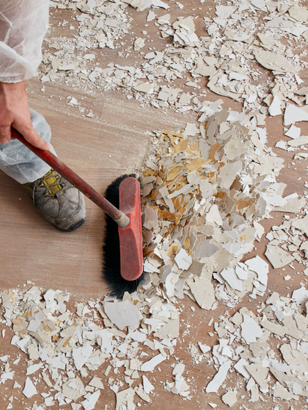 Un homme passe le balai sur des débris