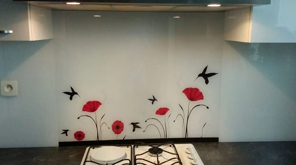 Crédence de cuisine ornée de coquelicots rouges et d'oiseaux noirs.