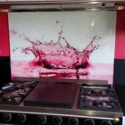 Cuisinière à gaz avec une crédence représentant une éclaboussure de liquide rose.