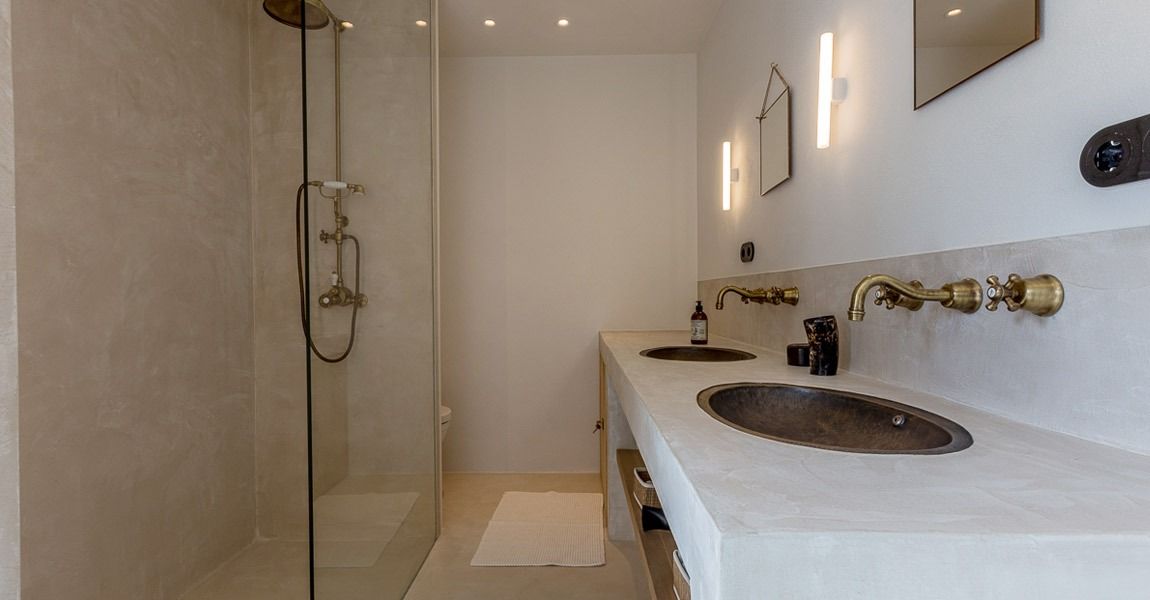 Un baño con dos lavabos y ducha.
