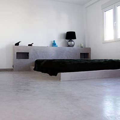 Un dormitorio con una cama y una lámpara en la pared.