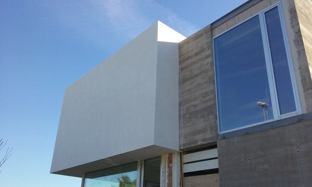 Un edificio con muchas ventanas y un cielo azul al fondo.