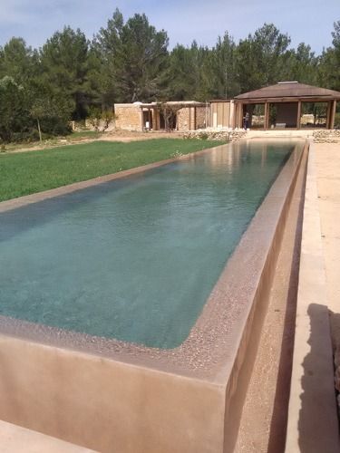 Una gran piscina con una casa al fondo.